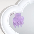 Macro detail of purple acetate hair claw clip reflected on a heart-shaped mirror base - Purple