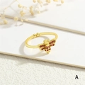 Makroaufnahme des 18k vergoldeten Bienenrings mit roten Zirkonflügeln auf Textur - Roter Zirkonia Bienenstil (RG0732-A)