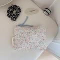Detail of floral quilted cotton pouch with 'Simple Wish' label and blue cord zipper pull - White with Pink Floral and Green Leaves