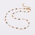 Dettaglio collana dorata con perline smeraldo, catena regolabile e chiusura a moschettone - Collana / Marrone