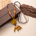 Detail of bohemian starfish necklace with yellow ceramic beads and brown woven rope - Yellow