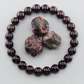 Deep red garnet beaded bracelet with raw natural stones on a clean grey background - Garnet