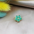 Macro shot of green enamel flower pendant with gold metal edges on silk background - Green
