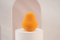 Orange pear-shaped makeup sponge puff for wet and dry use on a professional studio stand - Orange Pear