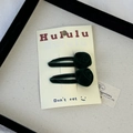 Detail of dark green velvet rose hair clips on display card within a decorative tray - Green