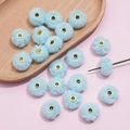 Detailed view of 20mm soft light blue faux rabbit fur pompom beads with golden eyelets - Light Blue