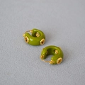 Macro-opname van groene emaille oorringen met goudkleurige metalen oogjes - Olijfgroen
