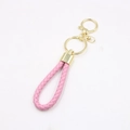 Detailed view of pink braided leather keychain with polished gold metal hardware - Pink