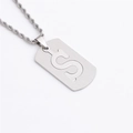 Gros plan d'un collier en acier inoxydable argenté avec un pendentif évidé en forme de S - Lettre S / Argent