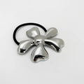 Detail van zilveren bloemvormige haarelastiek met zwart elastisch rubberen koord - Bloem / Zilver