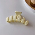 Detalle de una pinza para el cabello color crema en forma de onda con textura mate - Beige