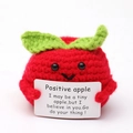 Close-up of a handmade crochet red apple with a positive message card on white background - Apple