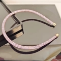 Elegant thin pink rhinestone headband with gold caps on a black reflective surface - Pink
