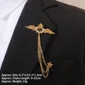 Détail d'une broche couronne dorée avec initiale S et chaînes sur un revers noir - Style Couronne Ailée Lettre S (TL24031)