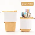 Gele telescopische canvas etui die als pennenhouder op het bureau staat op wit decor - Corduroy - Gember
