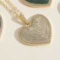 Vista macro del ciondolo a cuore in oro con dettagli in zirconi cubici scintillanti e pavé - Cuore Zirconia Bianca