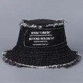 Dettaglio dei bordi sfilacciati e ricamo bianco su un cappello a secchiello in denim - Nero