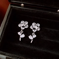 Detail van zilveren roos oorbellen met zirkonia in een zwart fluwelen sieradendoosje - Zilver