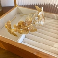 Macro shot of a golden metal headband featuring detailed butterfly cutouts in a jewelry box - Gold Metal Butterfly Headband