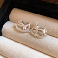 Detailed macro view of silver rocking horse stud earrings with hammered metal texture - Silver Needle Stud Earrings - Silver