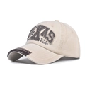 Détail d'une casquette baseball en toile délavée avec broderie TEXAS et bord en cuir - Beige
