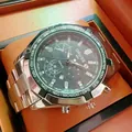 Close-up of mens chronograph watch with dark grey dial and green tachymeter bezel - Prestige Silver Band Black Face