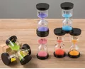 Colorful 1-minute sand timer set with black lids on a rustic wooden table surface - 45 Minutes