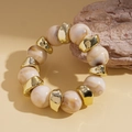 Macro detail of acrylic marble beads and irregular gold metal accents on elastic bracelet - Marble White Style / White