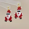 Close-up of handmade beaded Santa Claus earrings with red white and black crystal beads - Gold Ball Santa Claus-Silver Pin / Stud Earrings