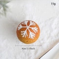 Close-up of 8cm warm orange Christmas snowflake ornament with glitter on white snow background - Sphere