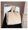 Detail einer weichen Plüsch-Tote-Bag in Cremeweiß, aufgehängt in minimalistischem Raum - Groß / Gebrochenes Weiß
