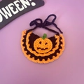 Detail van handgehaakte Halloween-halsband voor huisdieren met pompoen op paars decor - Pompoen Slabbetje