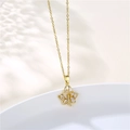 Détail macro du pendentif feuille dorée avec zircons sur un plateau céramique - Doré