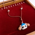 Détail du pendentif chien avec chapeau bleu et collier de perles sur velours rouge - Style Tête de Chien au Chapeau Bleu (WN2061)