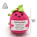 Macro detail of a hand-knitted pink positive pitaya plush toy with encouraging card - Fruit