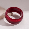 Close-up of deep red resin bangle with marble texture on a natural stone base - Red Marble Pattern Bangle