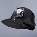 Close-up of black straw sun hat with large satin bow and UPF 50+ protection label. - M (56-58cm) / Black