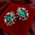 Vista macro de pendientes barrocos con esmeralda y perla sobre terciopelo rojo - Pin de plata-Verde