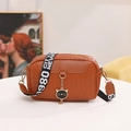 Brown woven leather crossbody bag with wide logo strap and gold cat charm detail - Brown