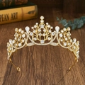 Nahaufnahme einer goldenen Barock-Tiara mit Wassertropfen-Kristallen auf Vintage-Holz - Gold mit weißem Zirkon