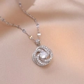 Elegant rotating silver flower necklace with clear central stone on pink satin - X1504 Flower Rotating