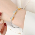 Silver snake chain bracelet featuring three gold heart-shaped charms with sparkling crystals - Heart Inlaid Rhinestone Style (E404) / Gold & Silver
