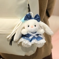White plush bunny keychain in dark blue polka dot dress on off-white backpack - Cool Denim Dress Style