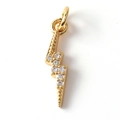 Macro shot of gold-plated lightning bolt charm with sparkling crystal zircon stones - Zirconia Lightning 08