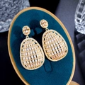 Dettaglio macro di orecchini geometrici placcati oro con micro-set di zirconi cubici - Oro