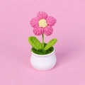 Detailaufnahme der handgefertigten rosa Häkelblume im weißen Topf mit Blattstruktur - Großer Einblumen-Stil / Fuchsia