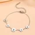 Silver daisy chain bracelet with five metal flowers on soft pink background - Silver Daisy Bracelet (B413)
