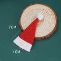 Close-up of 7x4cm mini red and white knitted Christmas hat on a rustic wood slice - Non-woven Lollipop Christmas Hat / 7x4cm