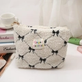 Kosmetiktasche aus Teddy-Fleece in Creme mit schwarzer Schleifenstickerei und Reißverschluss - Clutch Bag