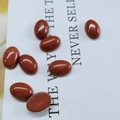 Macro shot of an oval red jasper gemstone cabochon with smooth polished texture - 10*14mm / Red Jasper